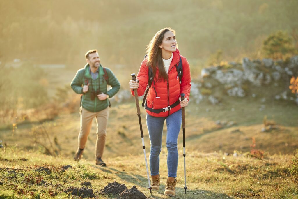 Couple walking on alpine meadow on a hiking trip in the mountains